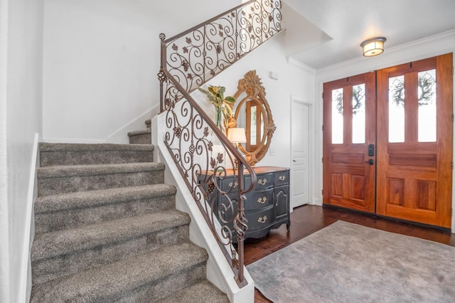 entrance foyer featuring dark wood-style floors, stairway, and crown molding