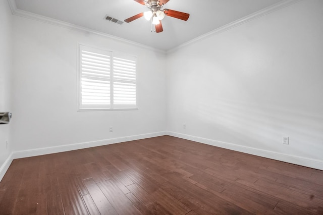 empty room with visible vents, a ceiling fan, dark wood finished floors, crown molding, and baseboards