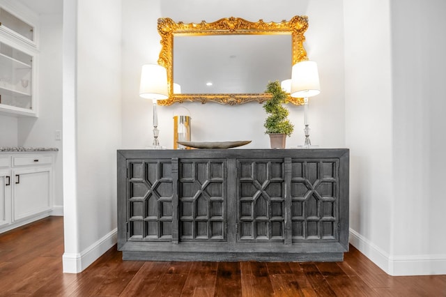 interior details featuring indoor wet bar, baseboards, and wood finished floors