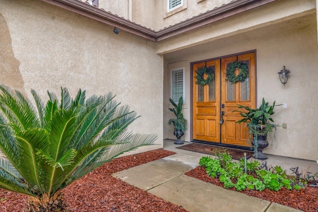 view of exterior entry with stucco siding