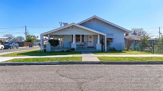 bungalow-style home with a porch and a front lawn