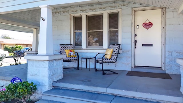 view of exterior entry featuring covered porch