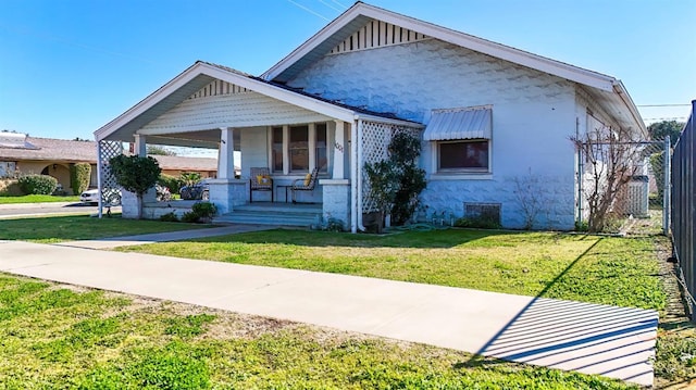 bungalow with a front yard and covered porch