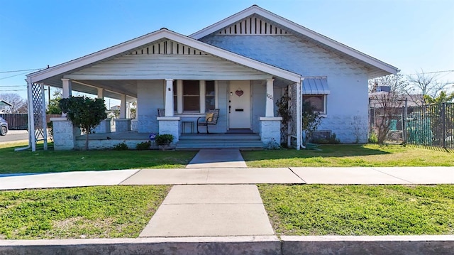 bungalow-style house featuring covered porch and a front lawn