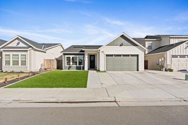 view of front of property featuring a garage, a front yard, and solar panels