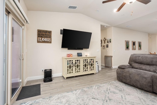 living room featuring hardwood / wood-style flooring, ceiling fan, and vaulted ceiling