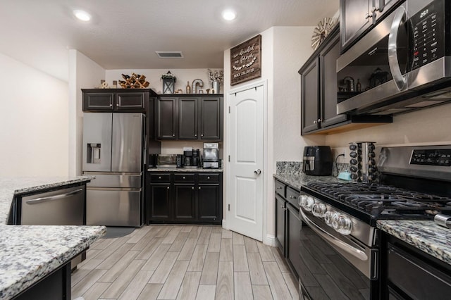 kitchen featuring light stone counters and appliances with stainless steel finishes