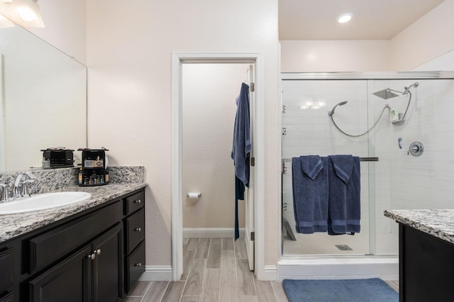 bathroom with vanity, hardwood / wood-style floors, and a shower with shower door