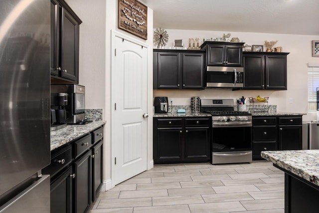 kitchen with appliances with stainless steel finishes and light stone counters