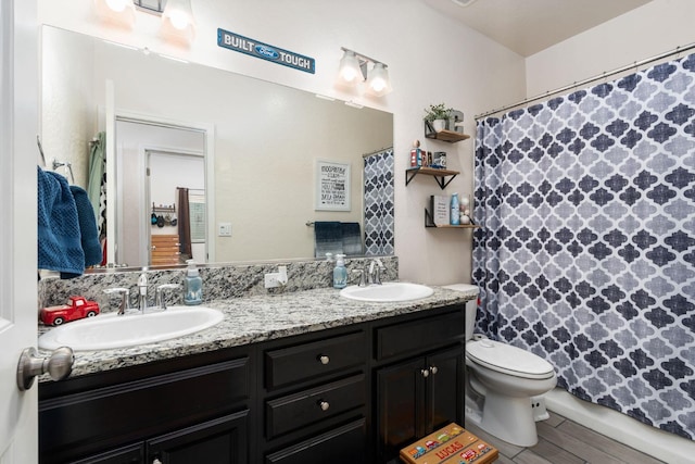 bathroom with hardwood / wood-style flooring, vanity, a shower with curtain, and toilet