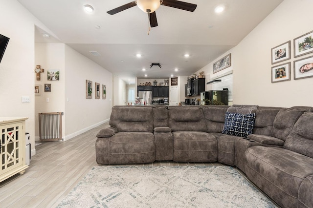 living room with ceiling fan and light hardwood / wood-style flooring