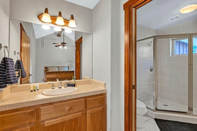 bathroom featuring tile patterned flooring, vanity, a shower with door, and toilet