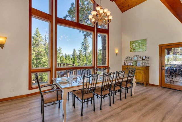 dining space with a chandelier, high vaulted ceiling, and light wood-type flooring