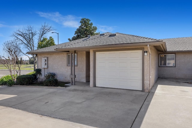 ranch-style house with a garage, concrete driveway, and stucco siding