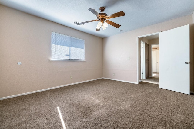 carpeted spare room with visible vents, a textured ceiling, baseboards, and a ceiling fan