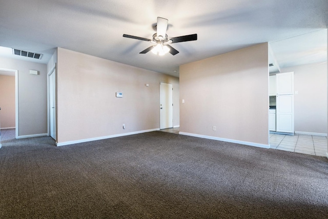 tiled empty room featuring a ceiling fan, carpet, visible vents, and baseboards