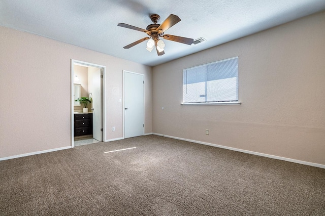 carpeted spare room featuring a textured ceiling, visible vents, and baseboards