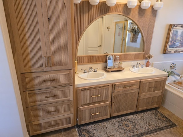 bathroom with tile patterned floors, vanity, and tiled tub