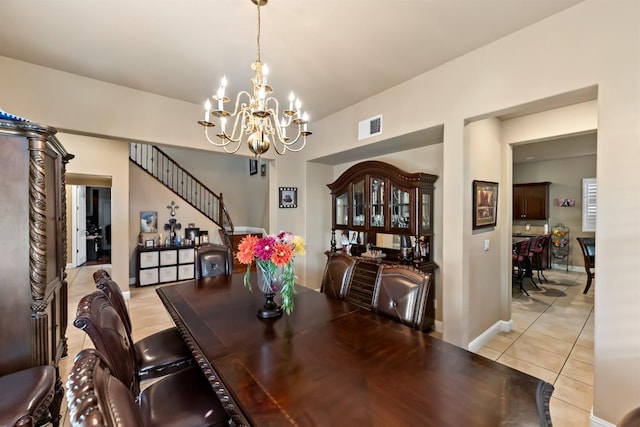 dining area with light tile patterned flooring and a chandelier