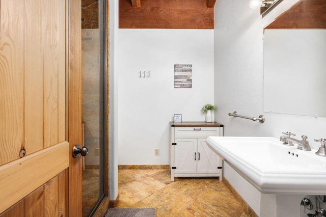 bathroom featuring an enclosed shower and sink