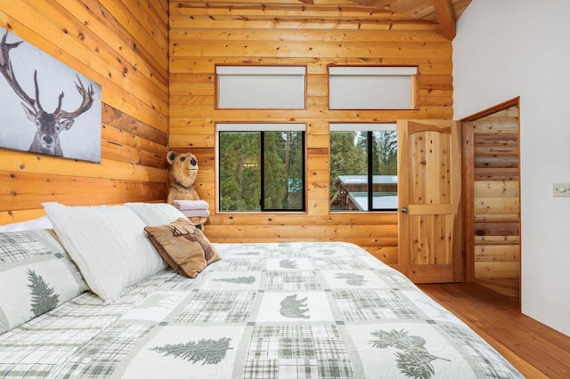 bedroom featuring a towering ceiling and wood-type flooring