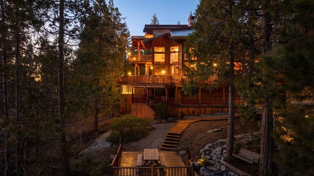 back of property with stairs, a chimney, and a wooden deck