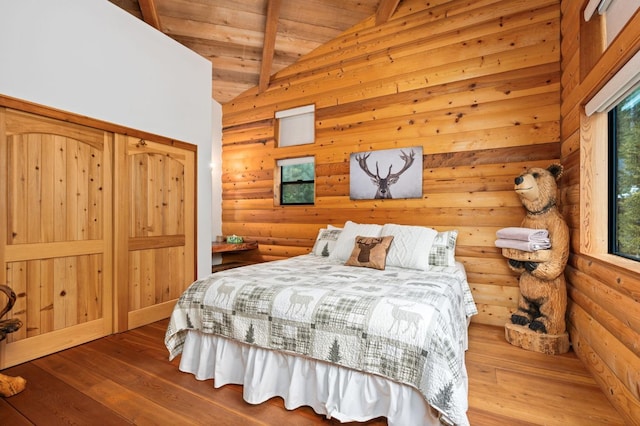 bedroom with wood ceiling, hardwood / wood-style flooring, beam ceiling, high vaulted ceiling, and log walls