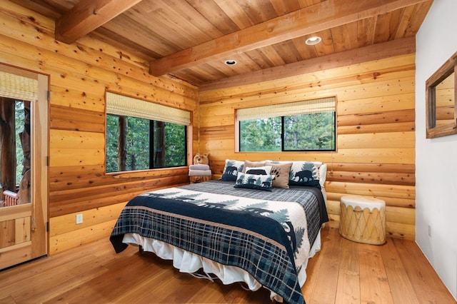 bedroom with beamed ceiling, hardwood / wood-style floors, wood ceiling, and multiple windows