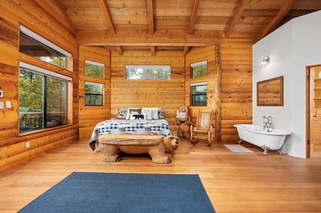 bedroom with beam ceiling, light hardwood / wood-style flooring, and wooden ceiling