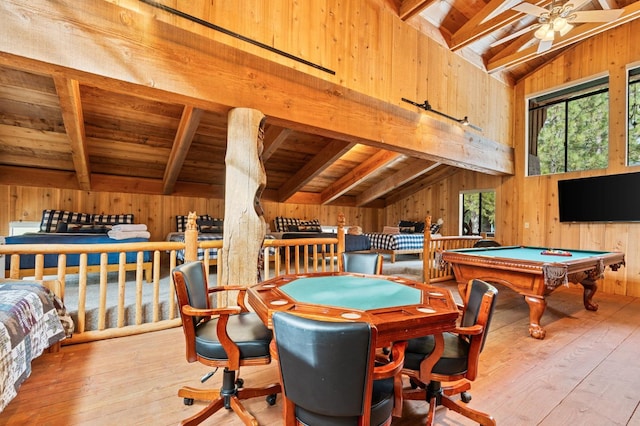 playroom featuring light hardwood / wood-style flooring, lofted ceiling with beams, and wood walls