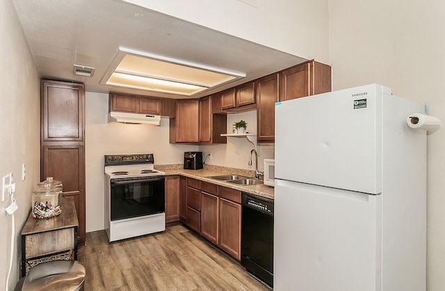 kitchen with sink, white appliances, and light hardwood / wood-style flooring