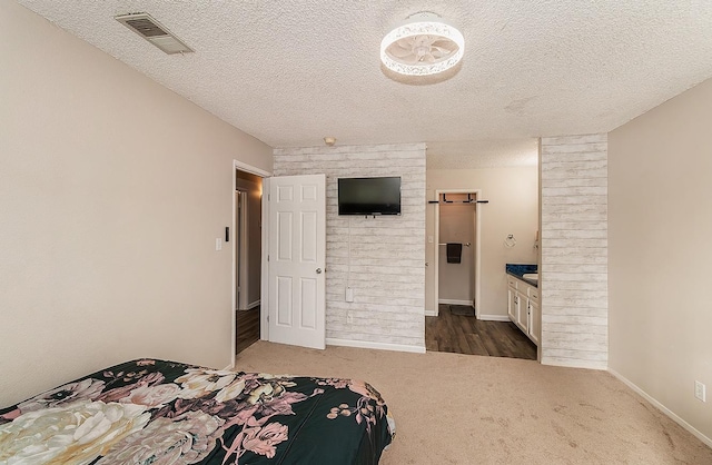 bedroom featuring a textured ceiling and dark carpet