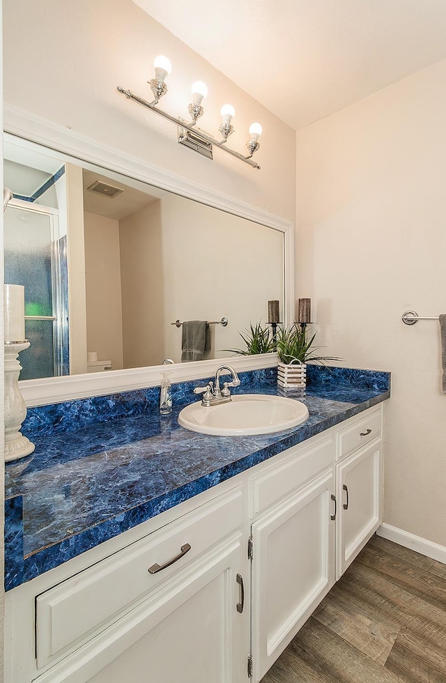 bathroom featuring vanity, hardwood / wood-style floors, and a shower with shower door