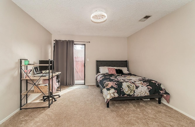 carpeted bedroom with a textured ceiling and access to outside