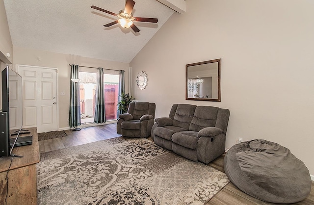 living room with hardwood / wood-style flooring, ceiling fan, a textured ceiling, and beam ceiling