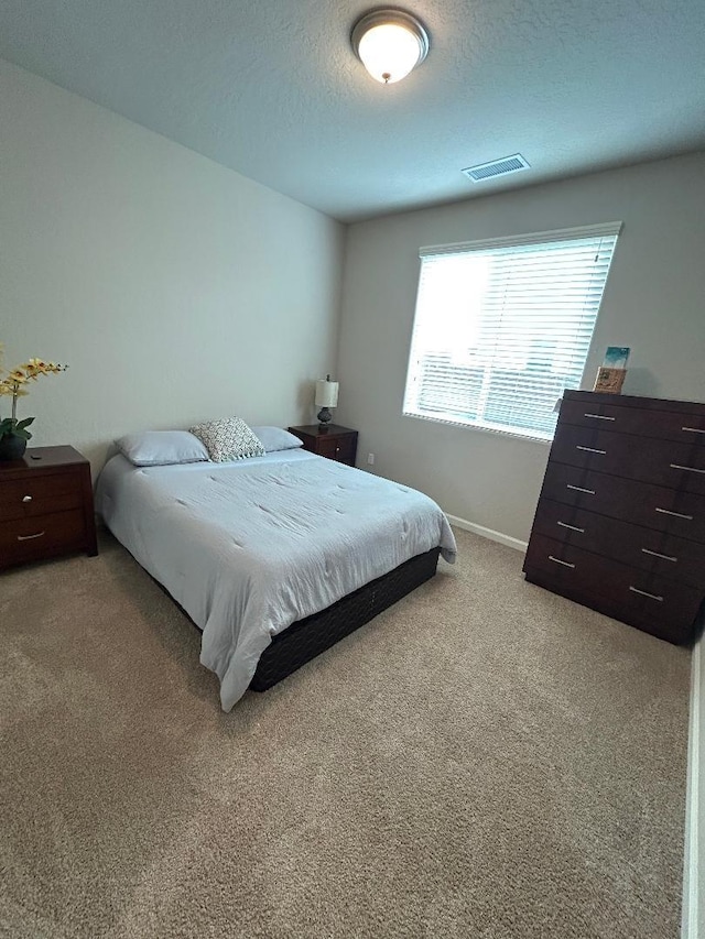 carpeted bedroom featuring a textured ceiling