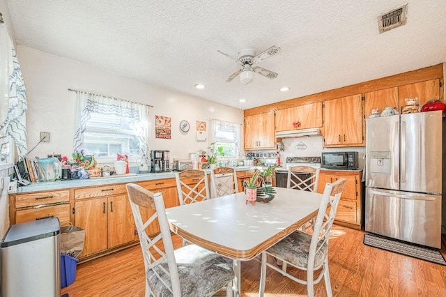 kitchen with a textured ceiling, stainless steel appliances, ceiling fan, and light wood-type flooring