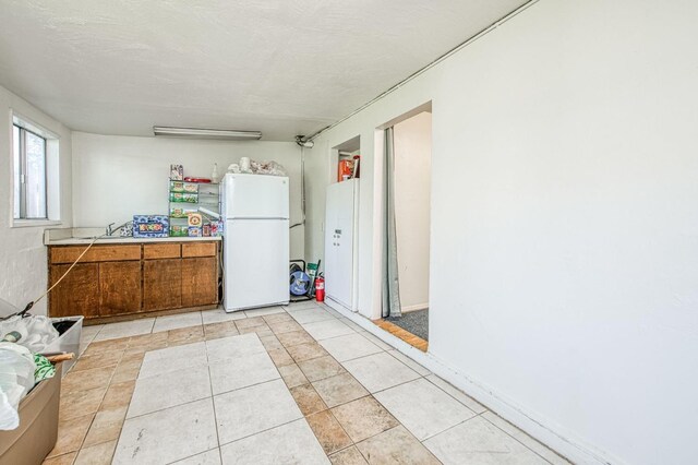 kitchen featuring white fridge and light tile patterned floors