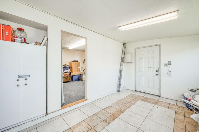 interior space with tile patterned floors and a textured ceiling