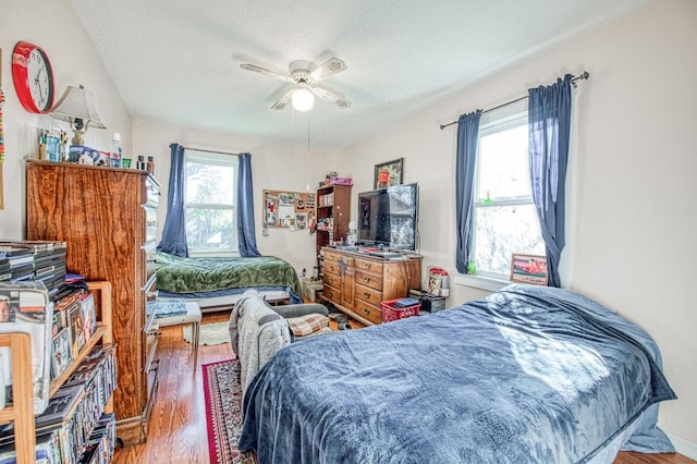 bedroom featuring hardwood / wood-style flooring, ceiling fan, and a textured ceiling