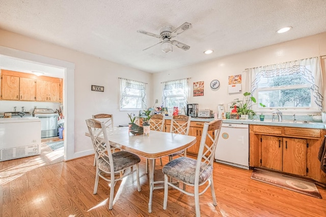 dining room with sink, washer / dryer, and light wood-type flooring