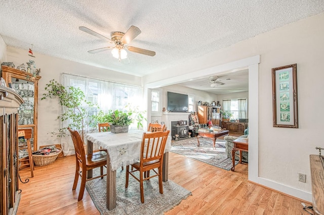 dining area with a textured ceiling, light hardwood / wood-style floors, and ceiling fan