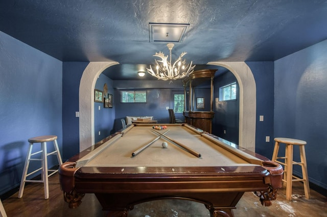 recreation room featuring an inviting chandelier and a textured ceiling