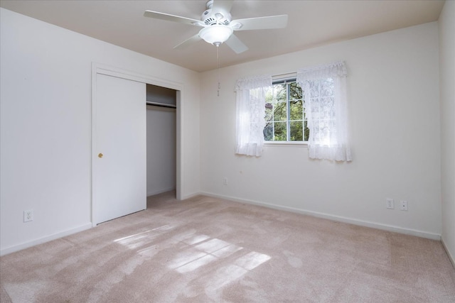 unfurnished bedroom featuring ceiling fan, a closet, and light carpet