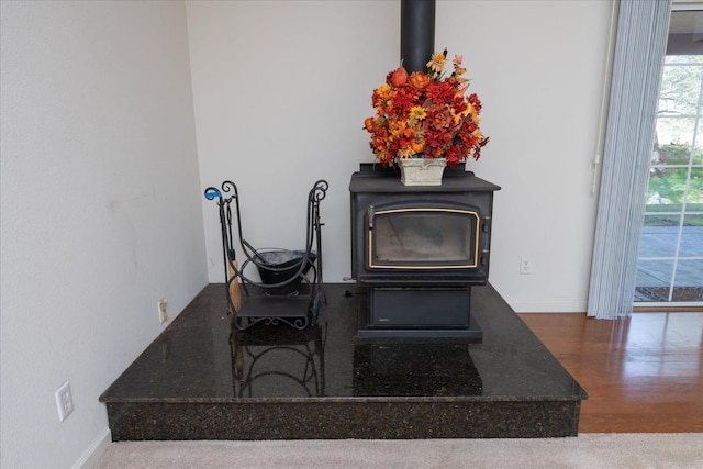 details with hardwood / wood-style flooring and a wood stove