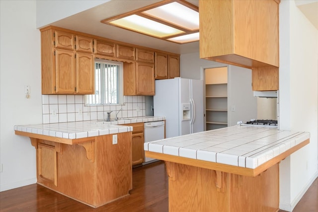 kitchen featuring tasteful backsplash, white appliances, tile countertops, and kitchen peninsula