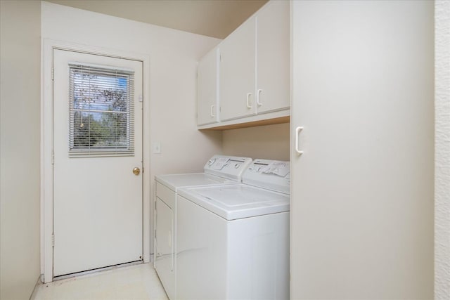 clothes washing area featuring cabinets and washer and dryer