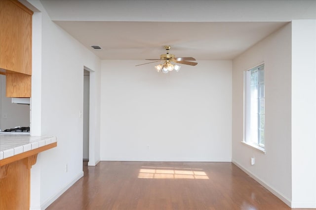 unfurnished dining area featuring ceiling fan and light wood-type flooring