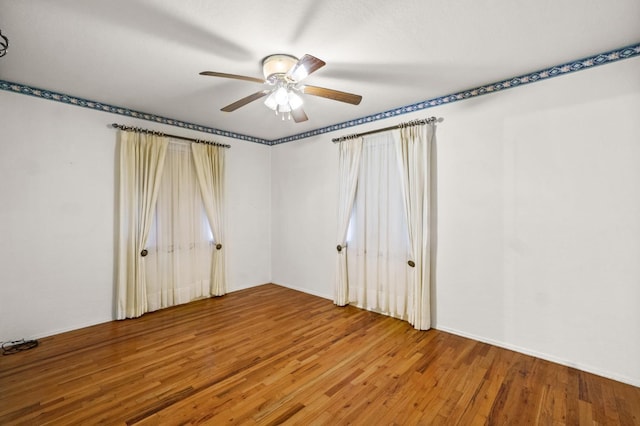 empty room with ceiling fan and hardwood / wood-style floors