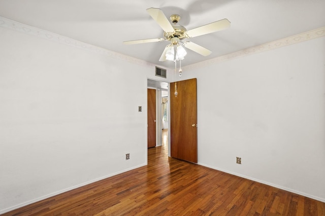 empty room with dark hardwood / wood-style flooring and ceiling fan